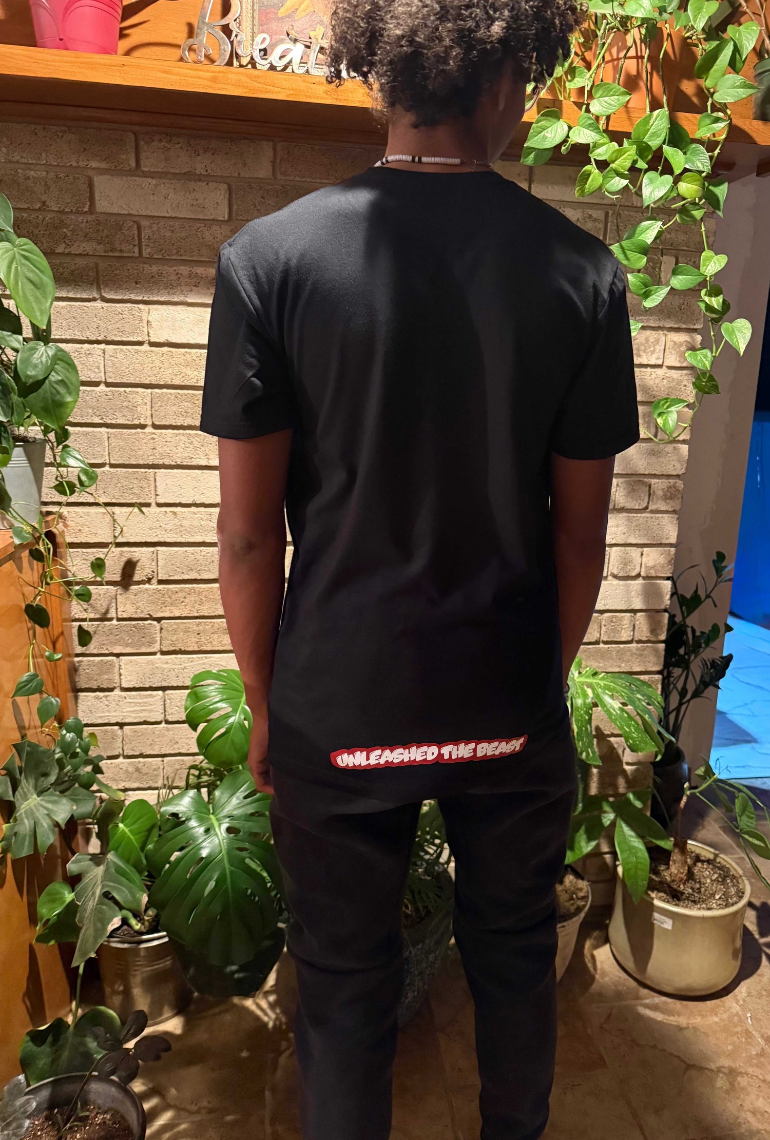 Back view of black graphic tee with Underbrim motivational slogan and small text reading Unleashed the Beast

